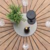 Zoom sur le plateau rond de la table en bois d'acacia